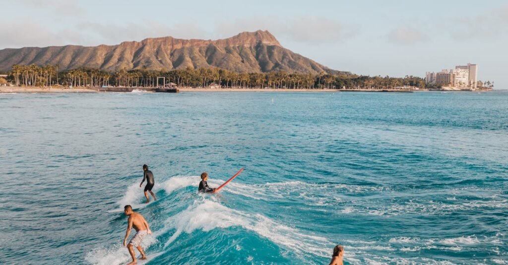 pexels-photo-4319836-4319836 Surfers enjoying a sunny day with waves at Diamond Head, Oahu, surrounded by stunning island scenery.